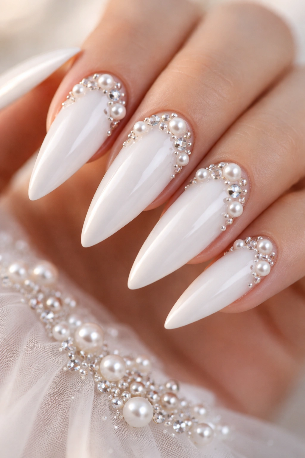 Close-up of white nails adorned with pearls and crystals