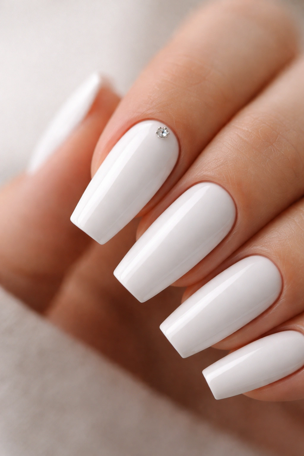 Close-up of white coffin nail with a tiny rhinestone accent