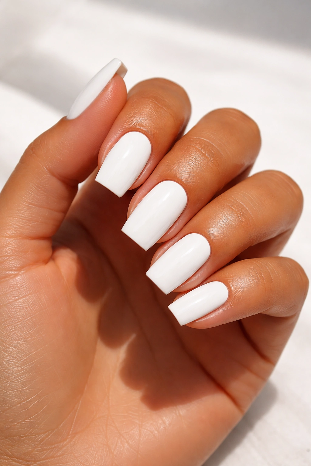Close-up of white nails on tan skin