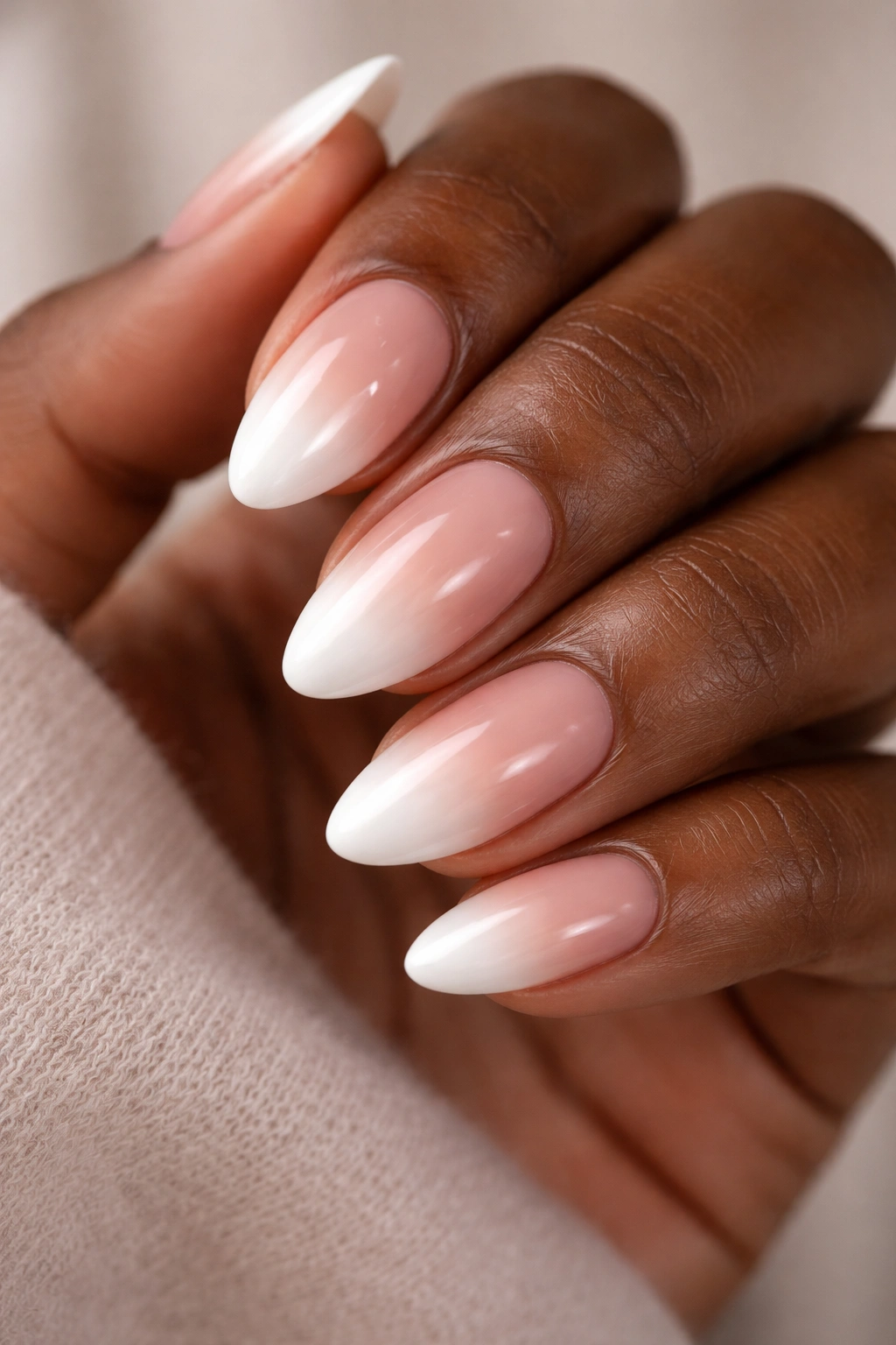 Close-up of white-tip ombré short almond nails