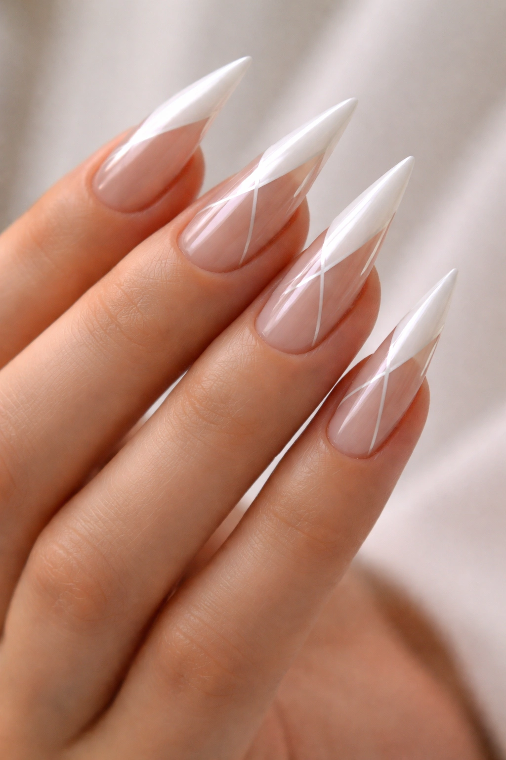 Close-up of white stiletto nails with sheer sections