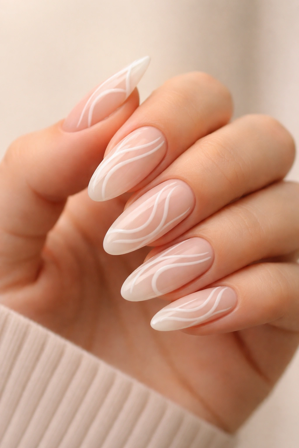 White swirl nail art on sheer nude long oval nails