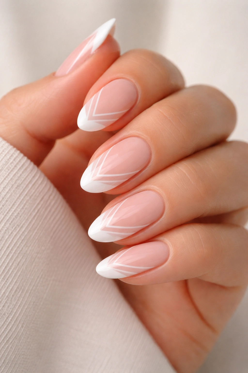 Close-up of short almond nails with white tip and matching base geometric design