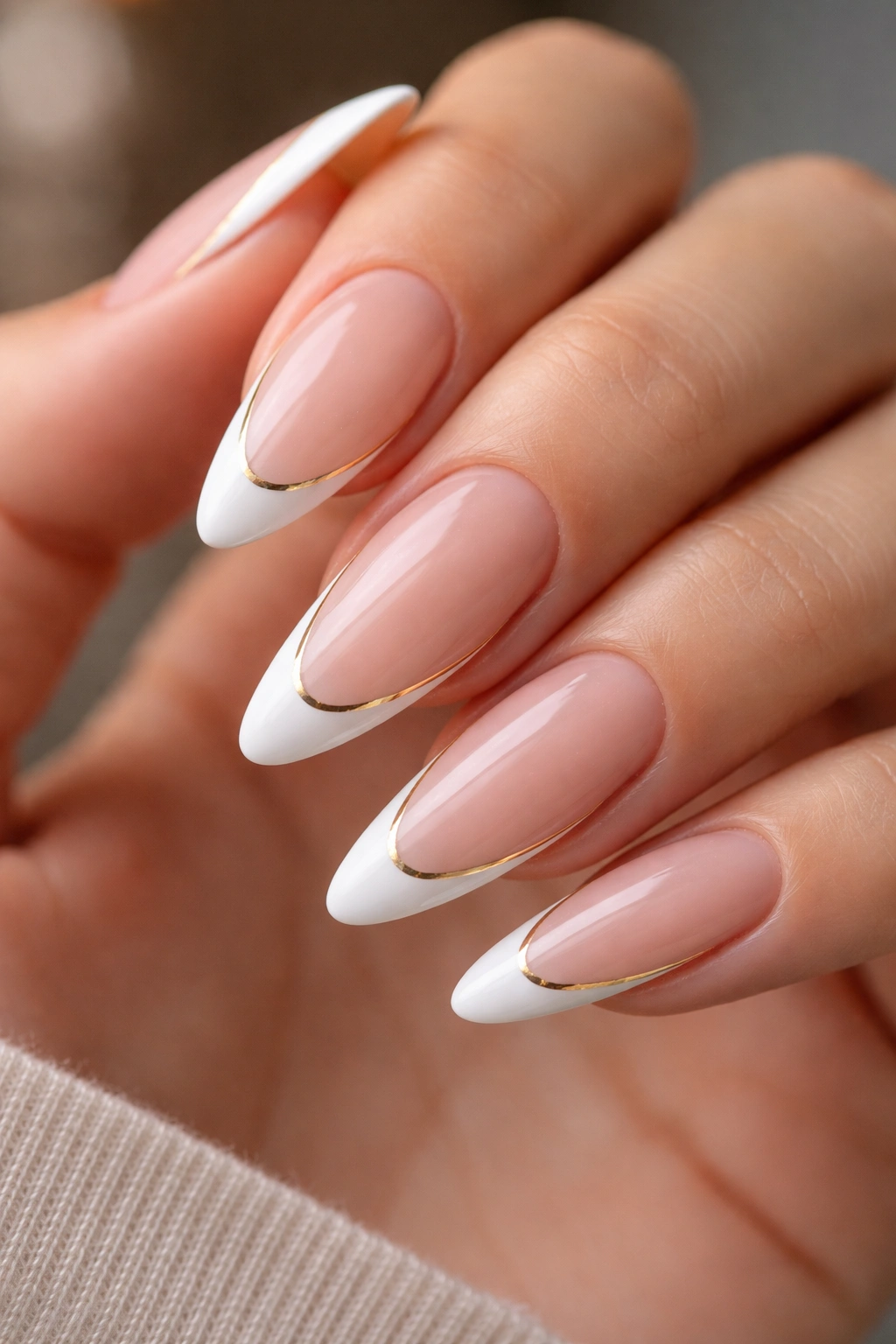 Almond nails with white tips and a thin gold outline