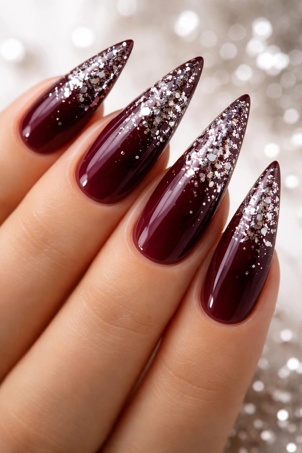 Wine-colored stiletto nails with silver confetti accents