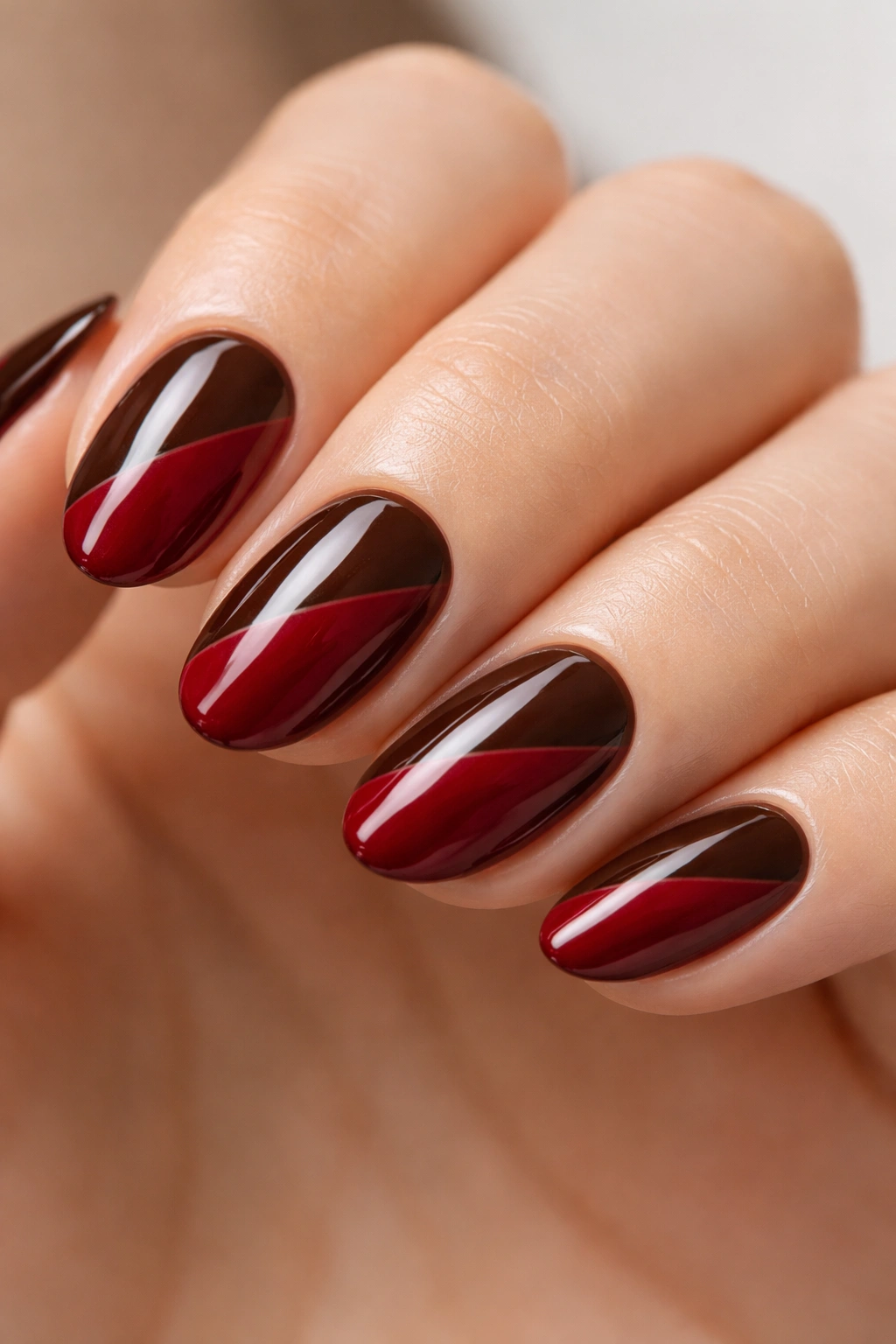 Short almond nails with diagonal wine red and espresso brown split