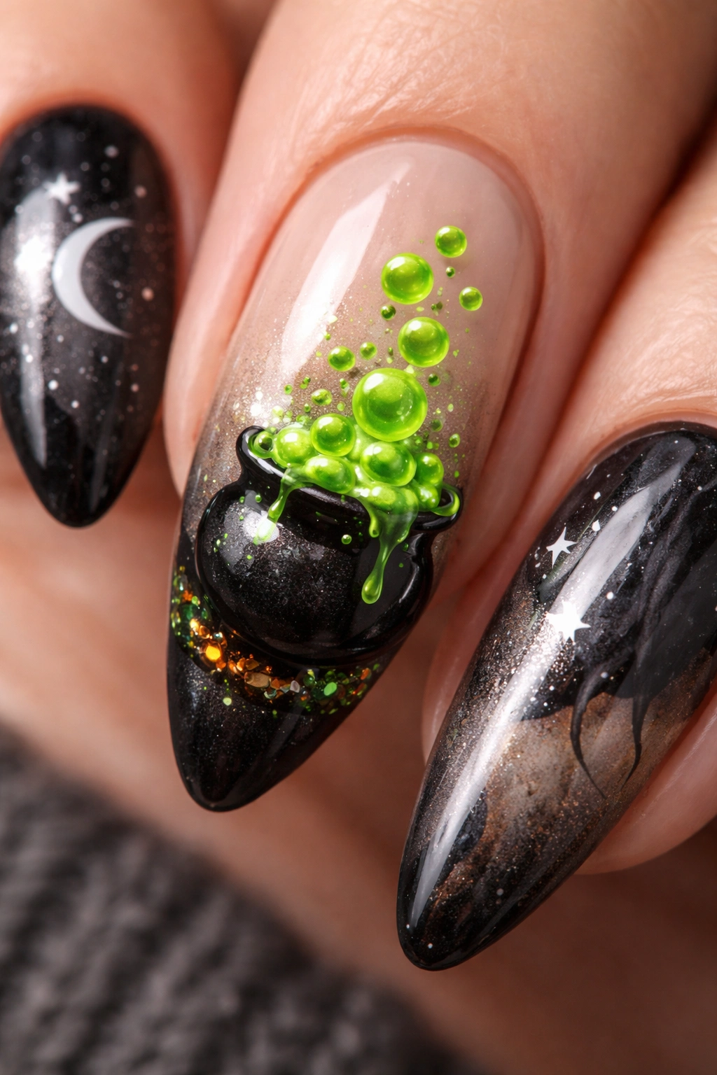 Almond nails featuring a tiny black cauldron on an accent nail with green bubbling potion and white highlights