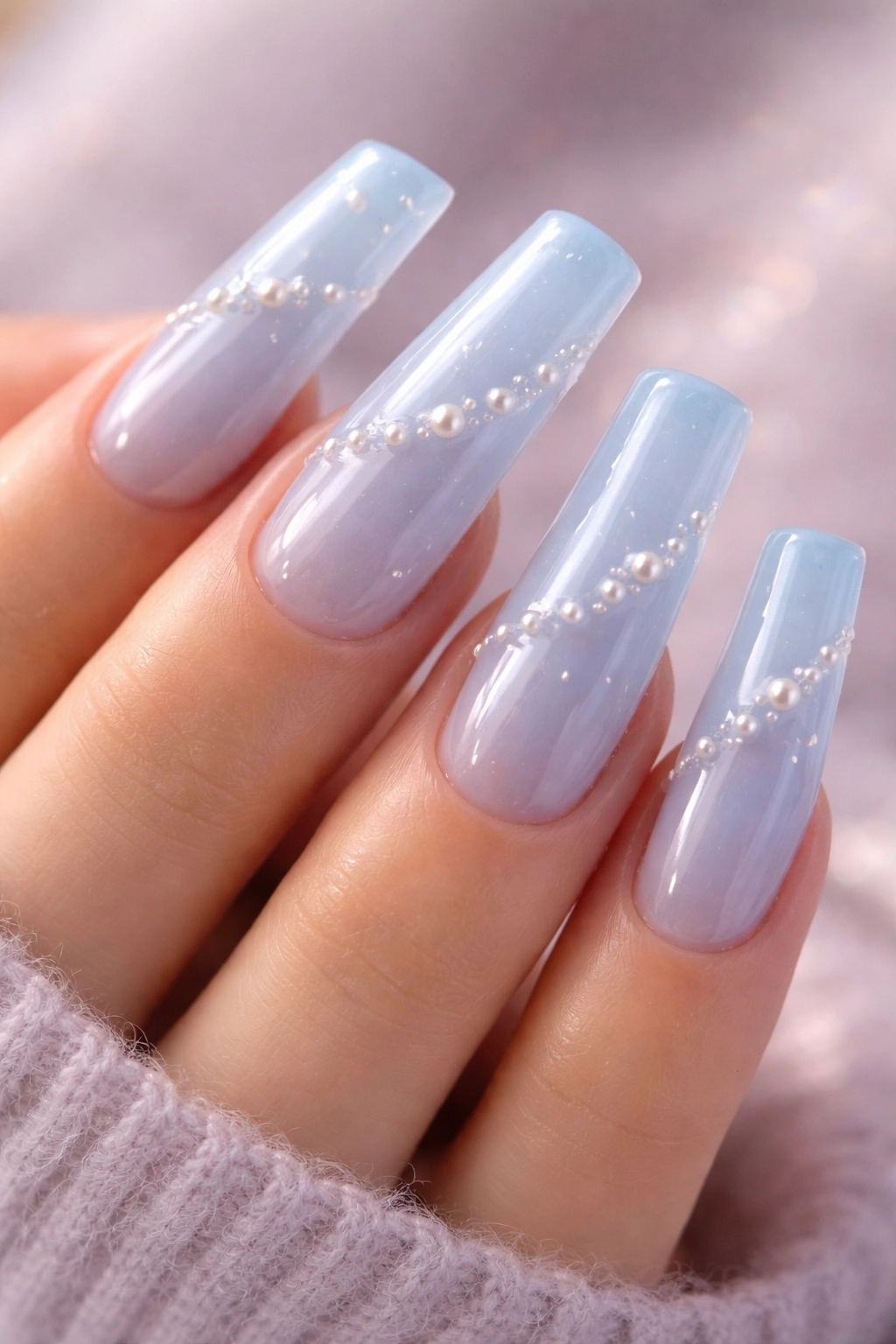 Close-up of Y2K baby blue jelly nails with pearl accents on long duck nails