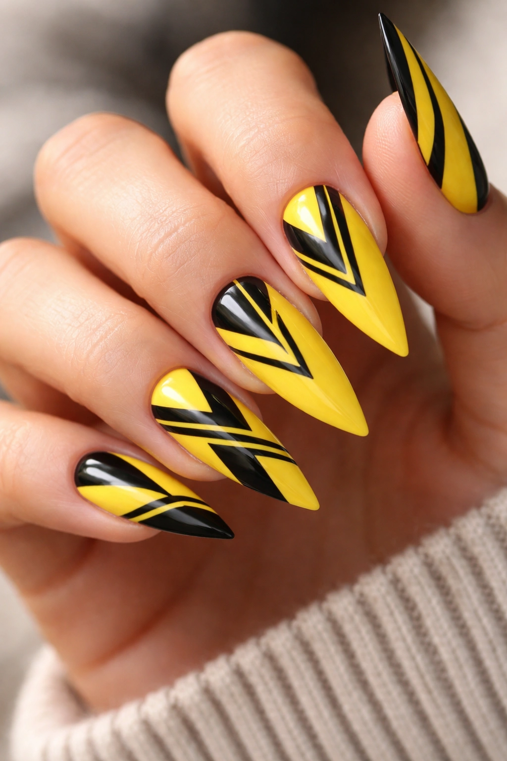 Yellow nails with black geometric patterns in close-up
