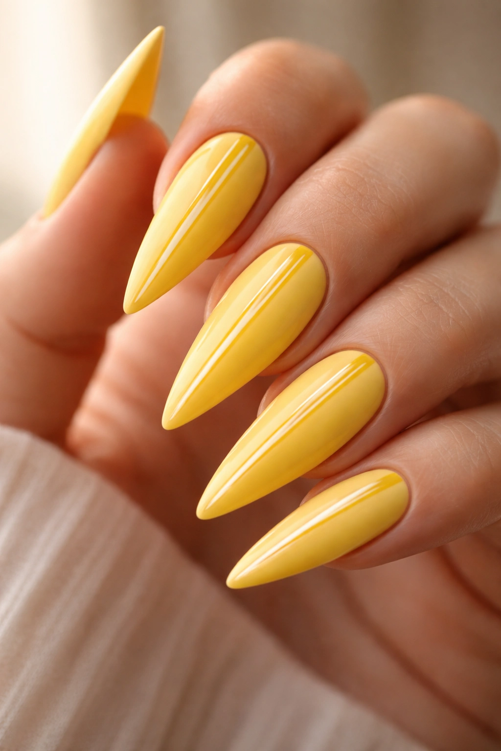Matte yellow stiletto nails with a single glossy accent detail