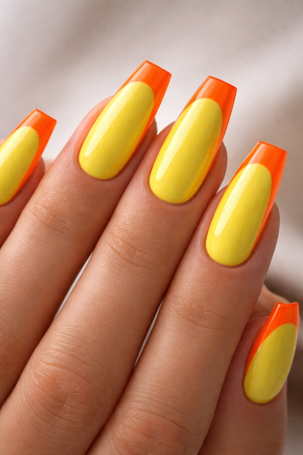 Coffin nails with sunshine yellow base and neon orange reverse French tips