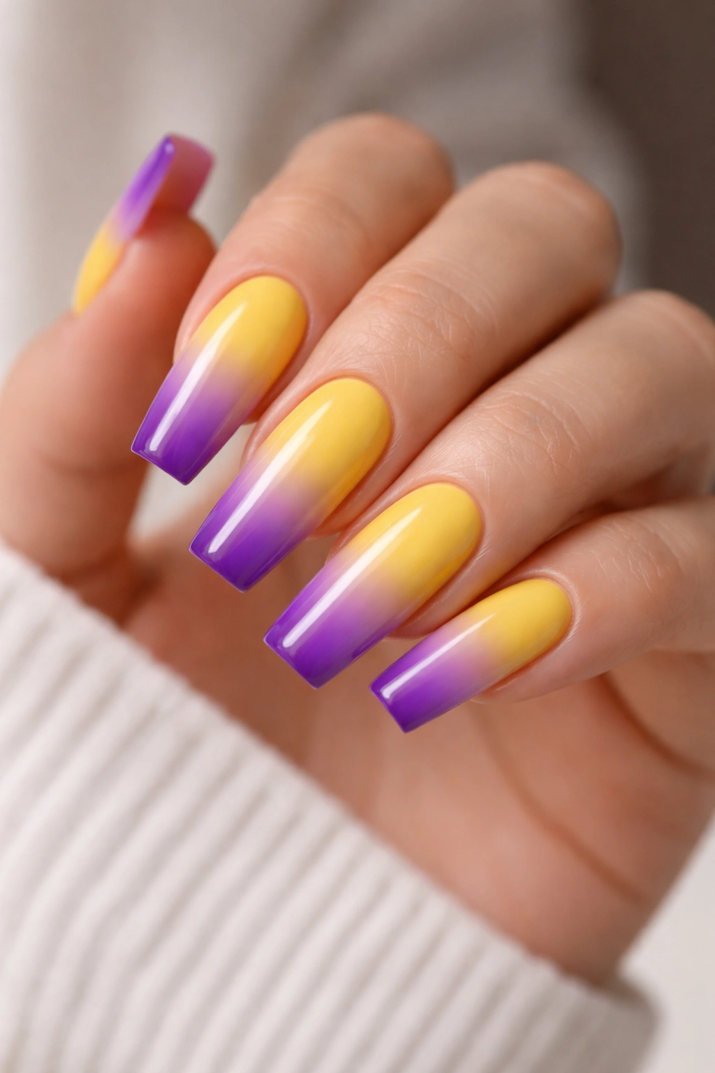 Coffin nails with yellow to purple ombré tips.