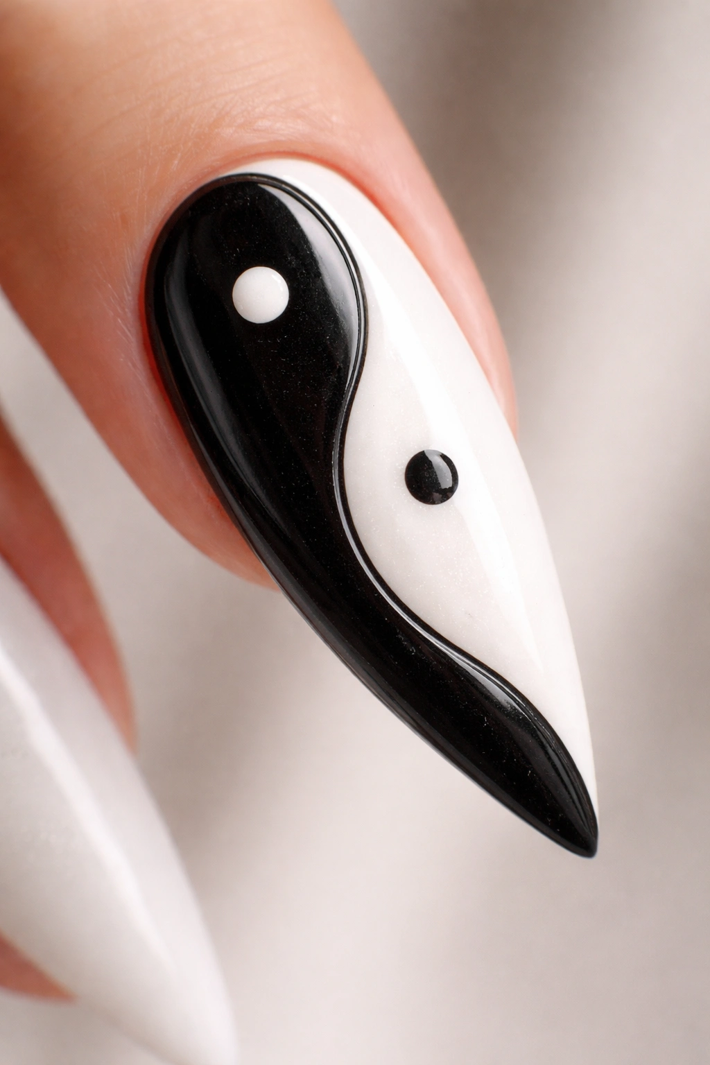 Close-up of a stiletto nail with black and white yin-yang design