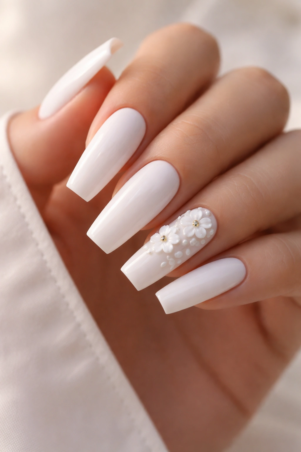 Nails with tiny 3D white floral accents on coffin shape