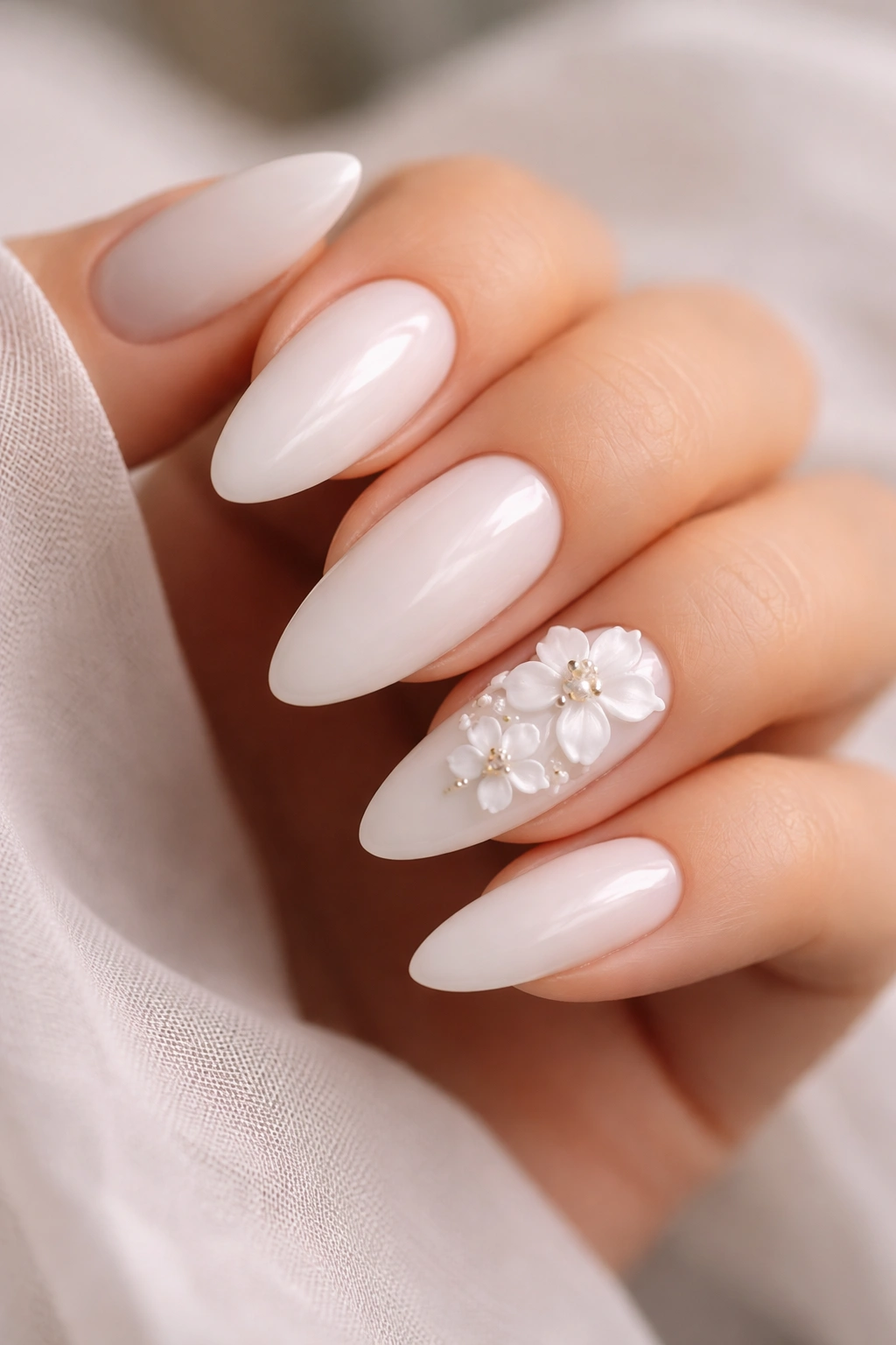 Almond nails with subtle 3D white floral accents on accent nails