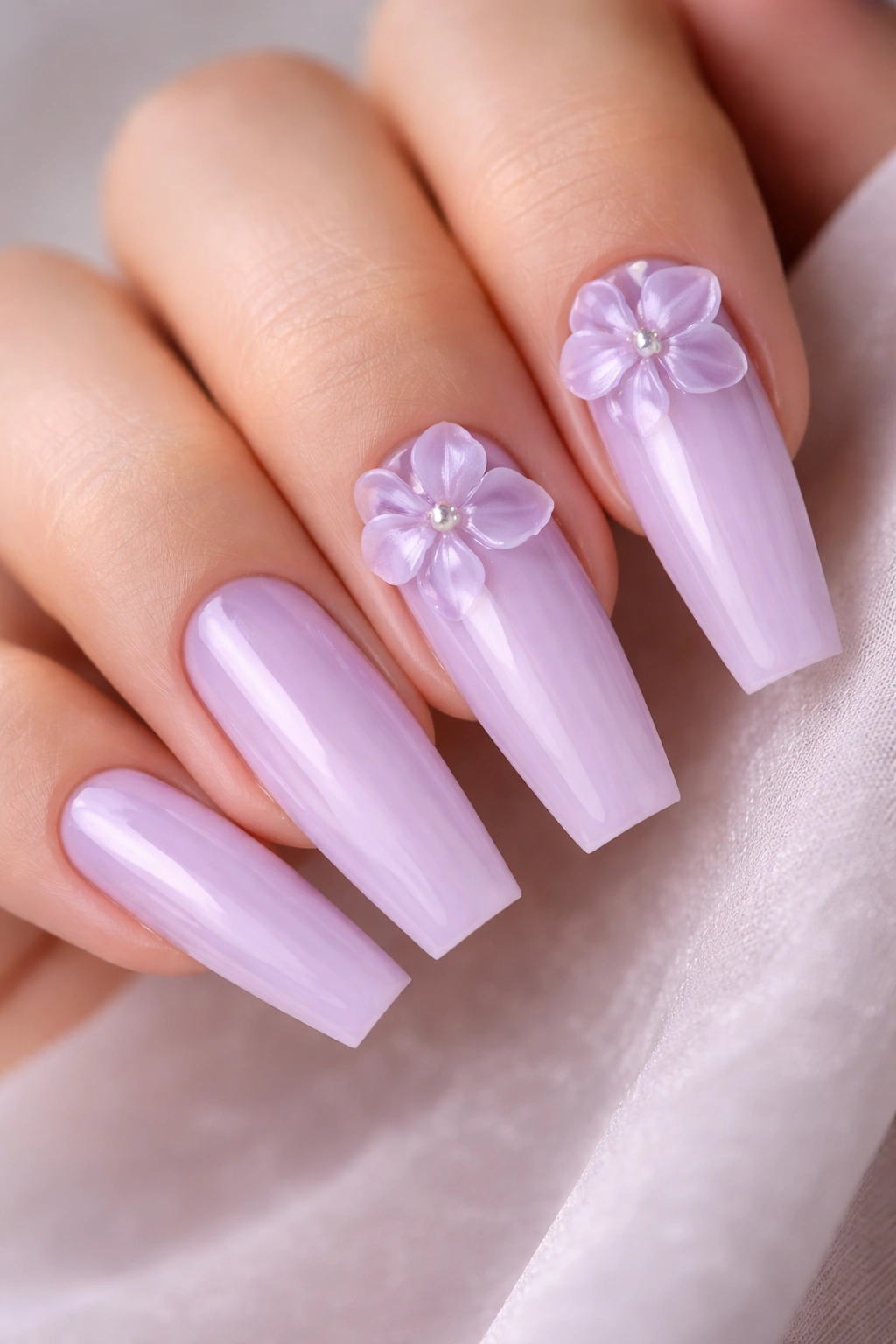Close-up of coffin nails with 3D lilac flowers near the cuticle and pearl centers