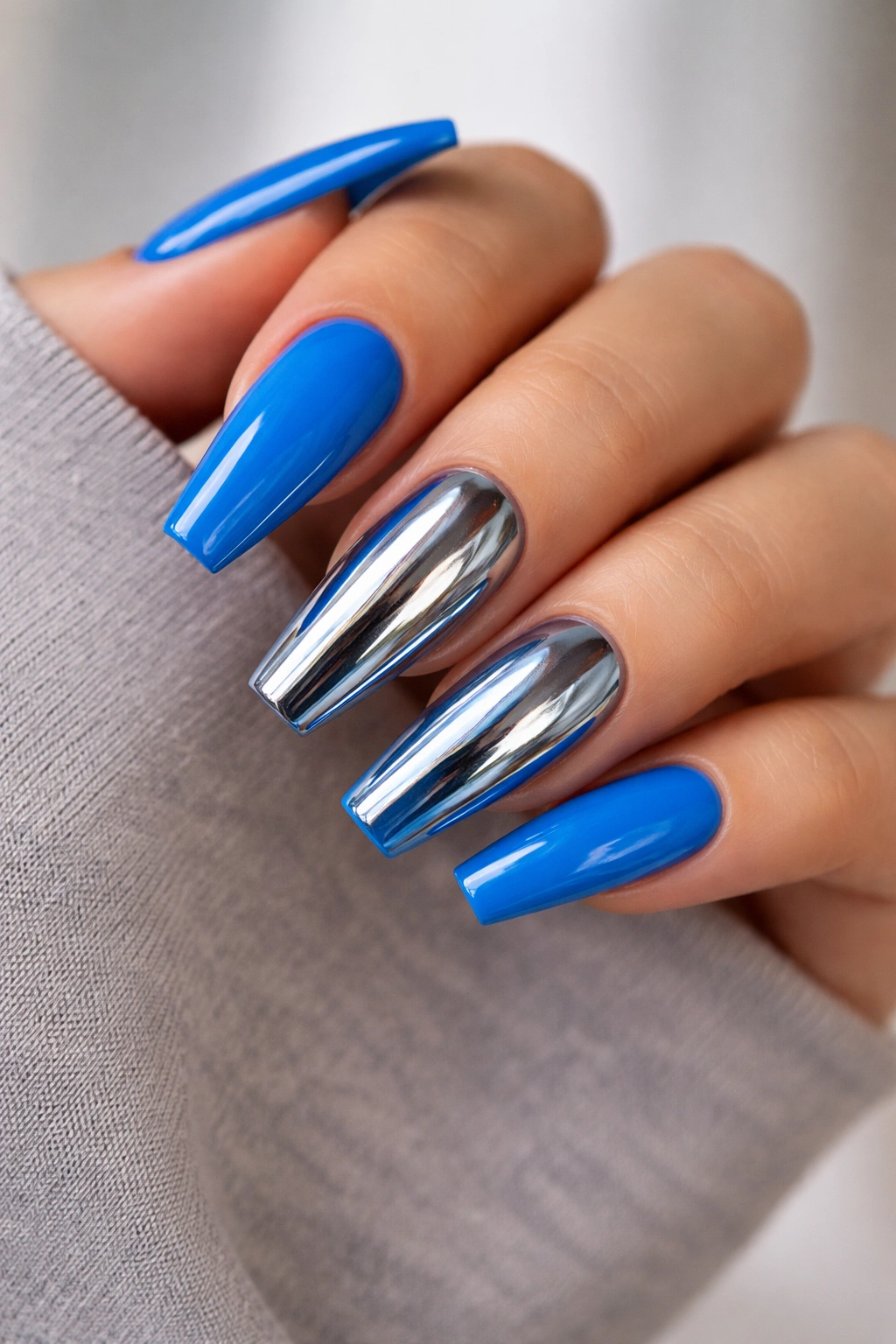 Close-up of acid blue coffin nails with chrome accent nails
