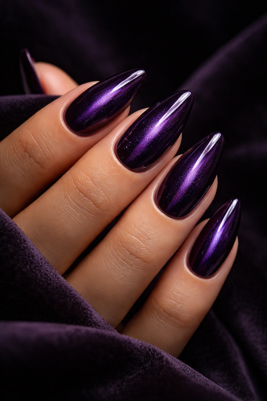Almond nails with amethyst cat-eye effect and narrow center line.