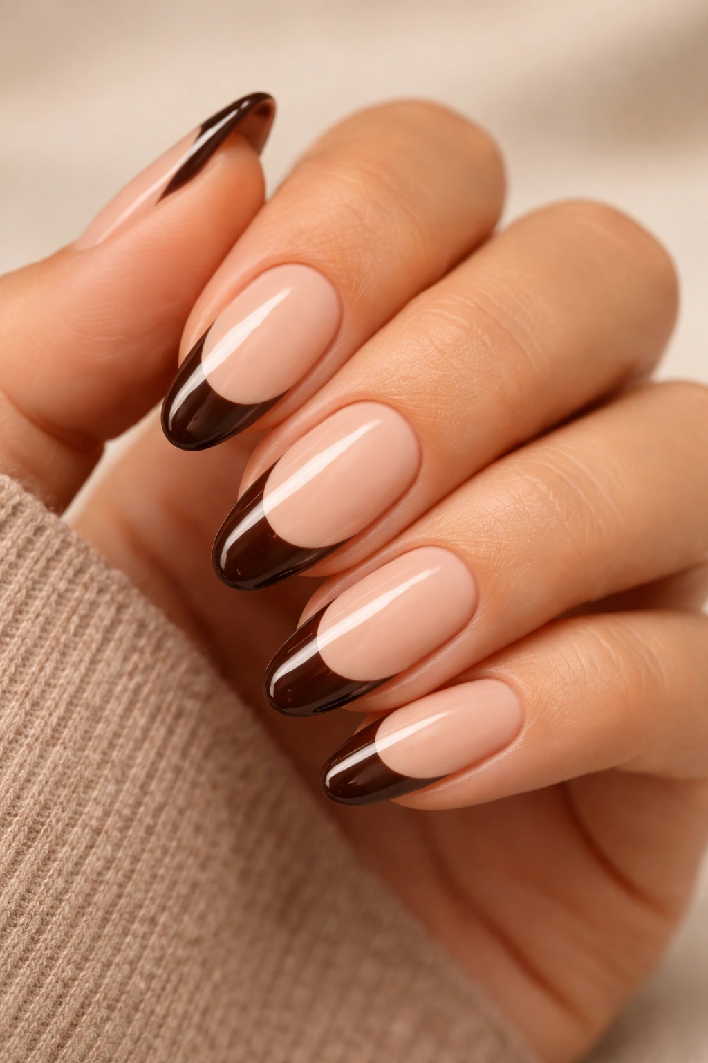 Almond nails with chocolate brown French tips on nude base