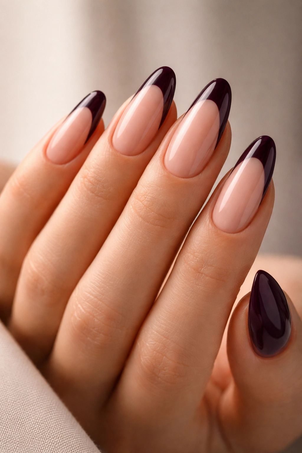 Almond nails with nude base and deep eggplant tips.