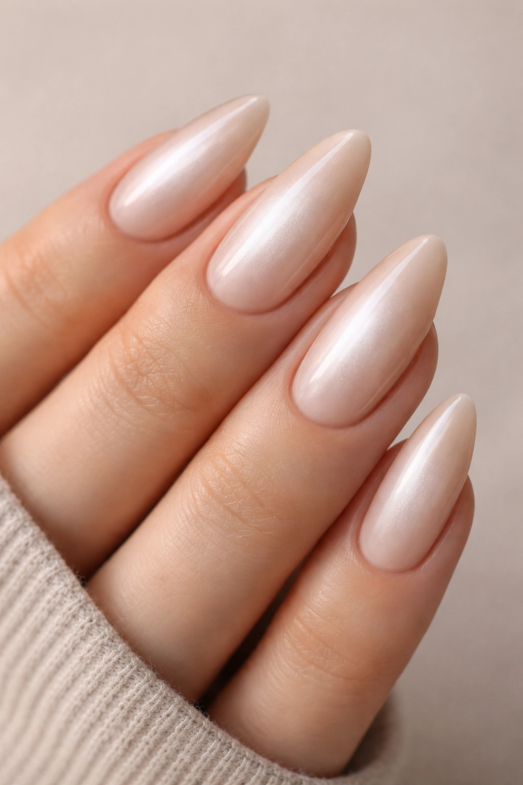 Almond nails with pearl beige shift showing a pearl-white center glow and beige edge.