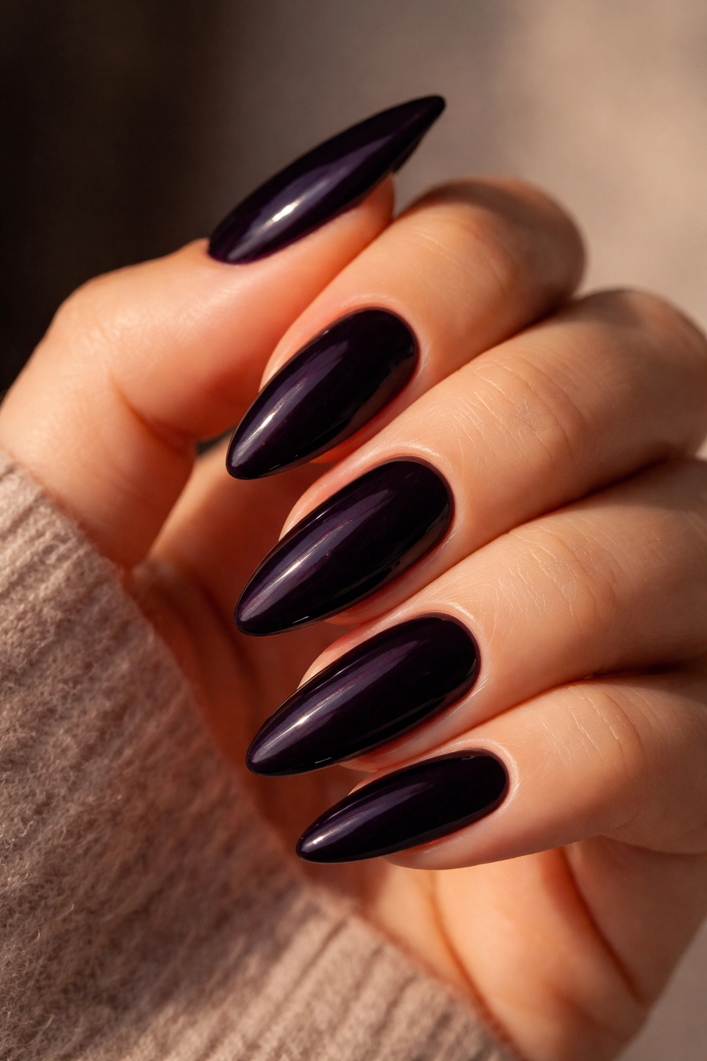 Almond nails in near-black plum cream with high-gloss finish.