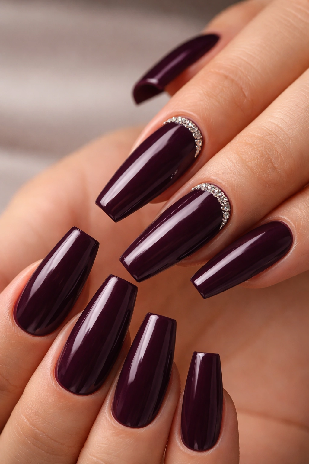 Glossy deep aubergine coffin nails with crystal cuticle frame on two fingers
