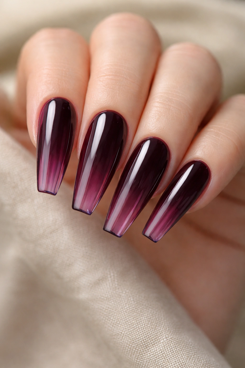 Close-up of aubergine jelly coffin nails with stained-glass depth