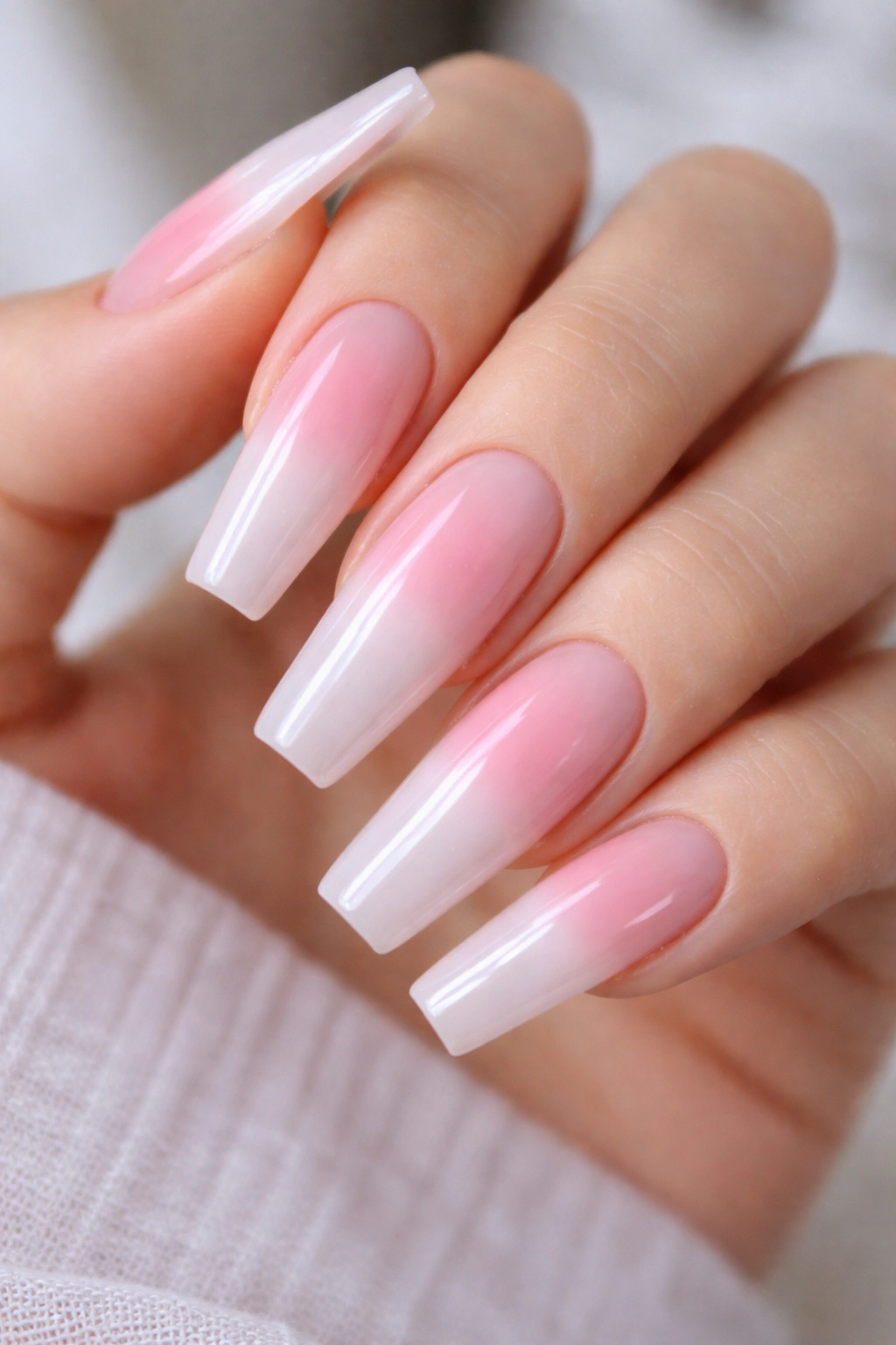 Close-up of long coffin nails with soft aura blush center glow