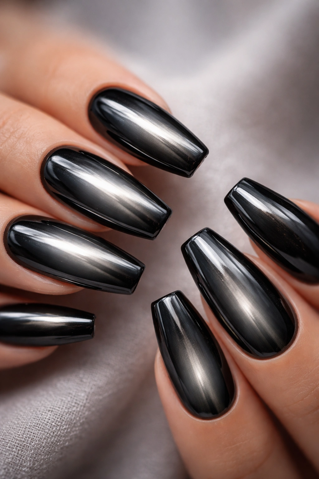 Close-up of coffin nails with aura-centered pewter glow on black chrome