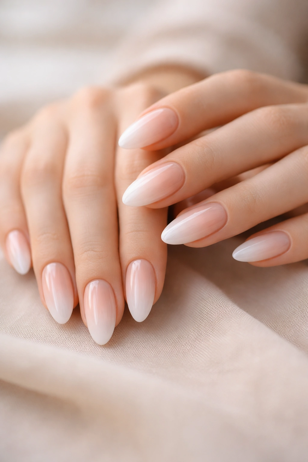 Close-up of aura almond nails with centered glow on almond-shaped nails against neutral background.