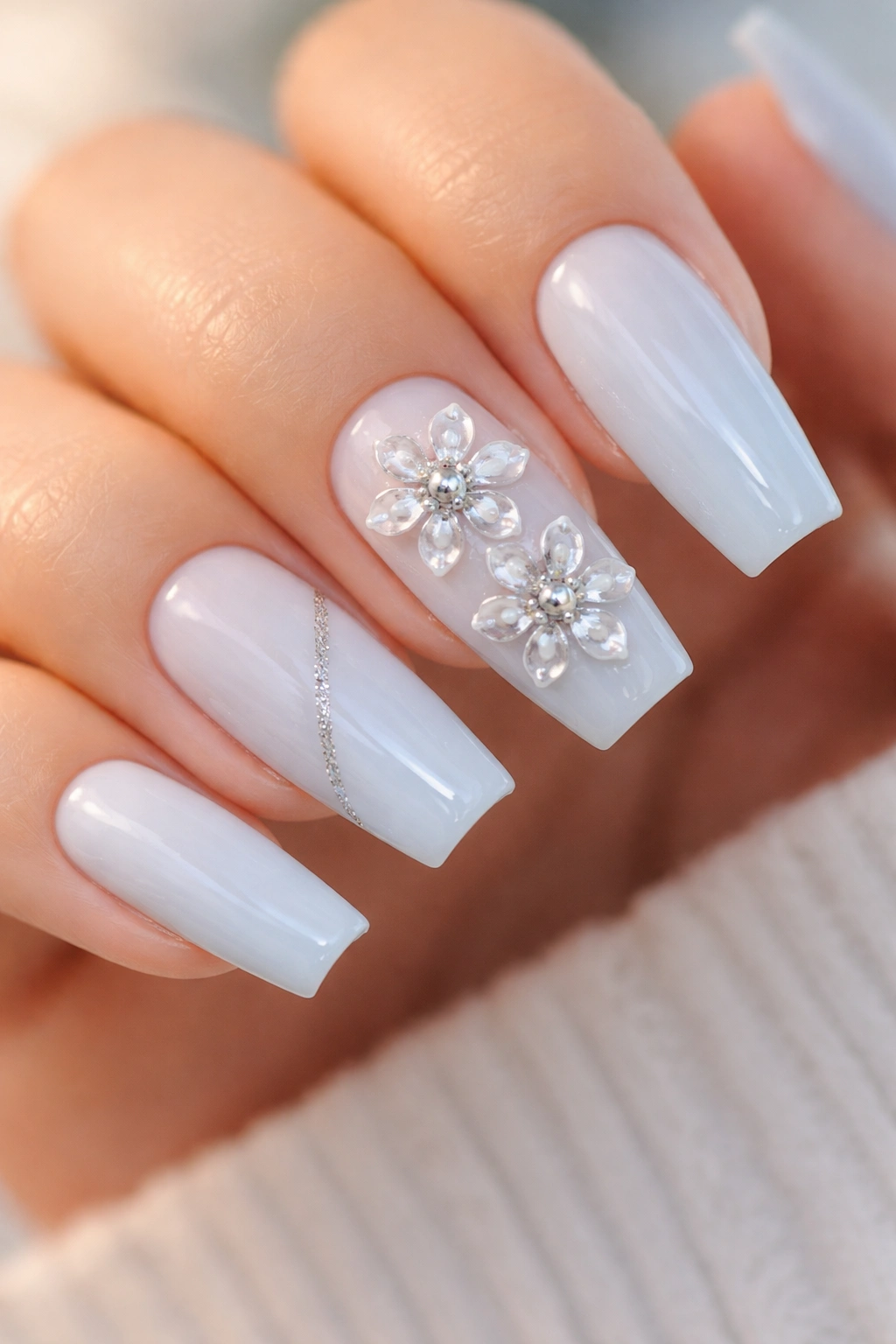 Close-up baby blue coffin nails with chrome flower centers.