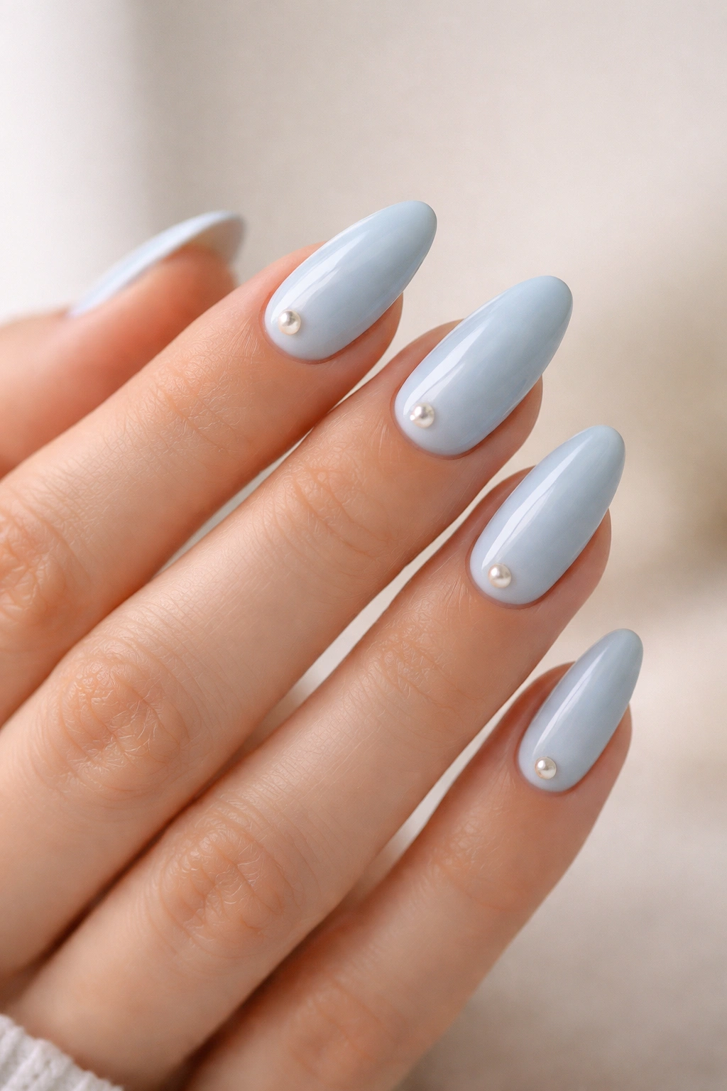 Baby blue almond nails with pearl accents close-up