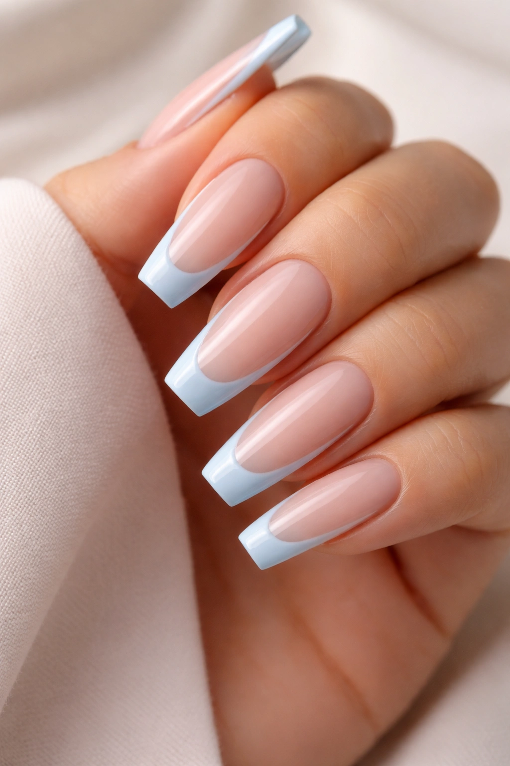 Nails with a narrow baby blue curved smile line on coffin nails
