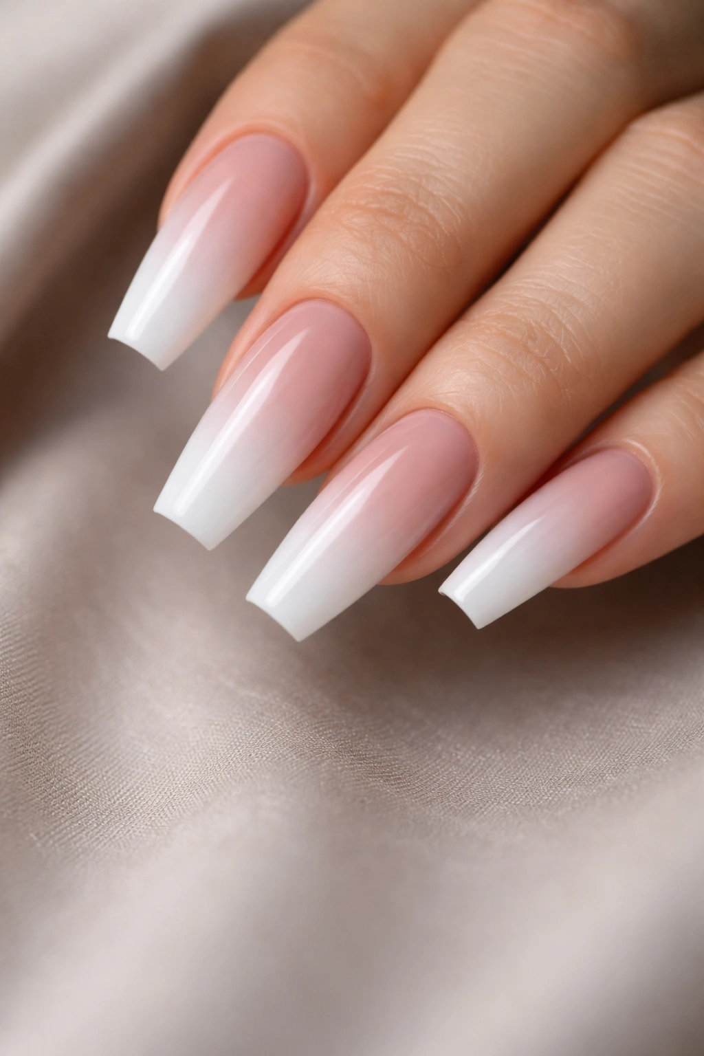 Close-up of baby boomer ombre coffin nails with pink to white gradient