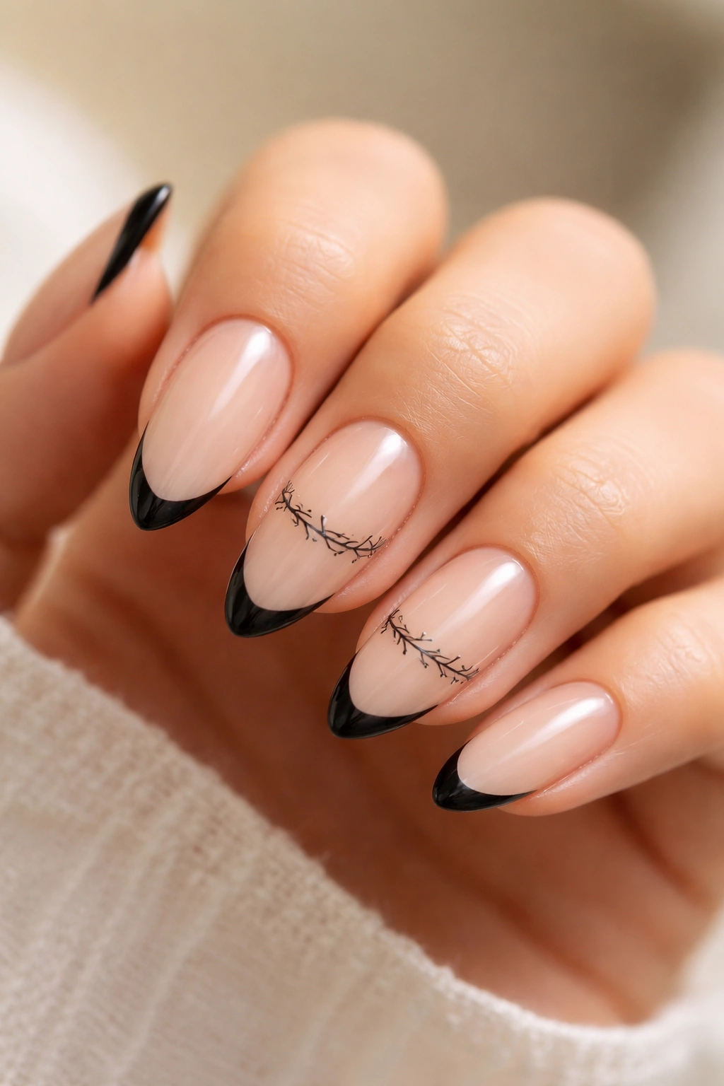 Almond nails with sheer base, black tips and barbed wire