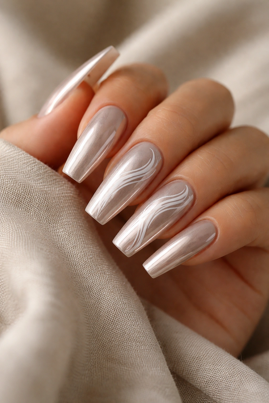 Beige chrome nails with fine white swirls on coffin shape