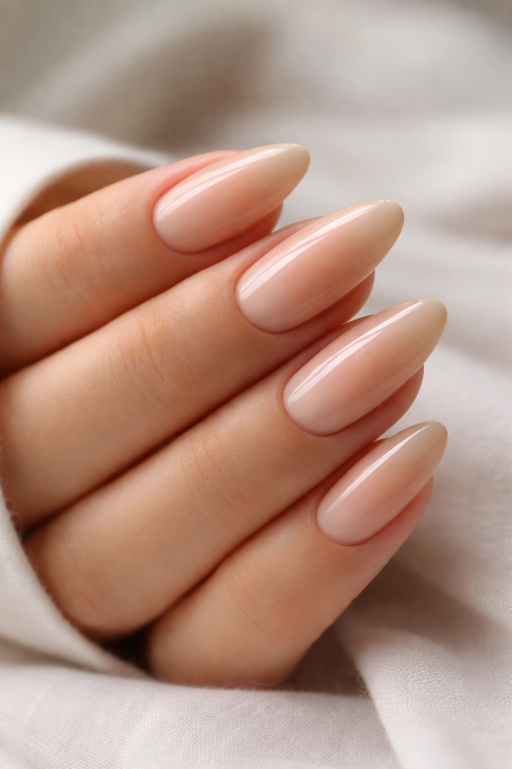 Close-up of beige ombré fade on almond nails
