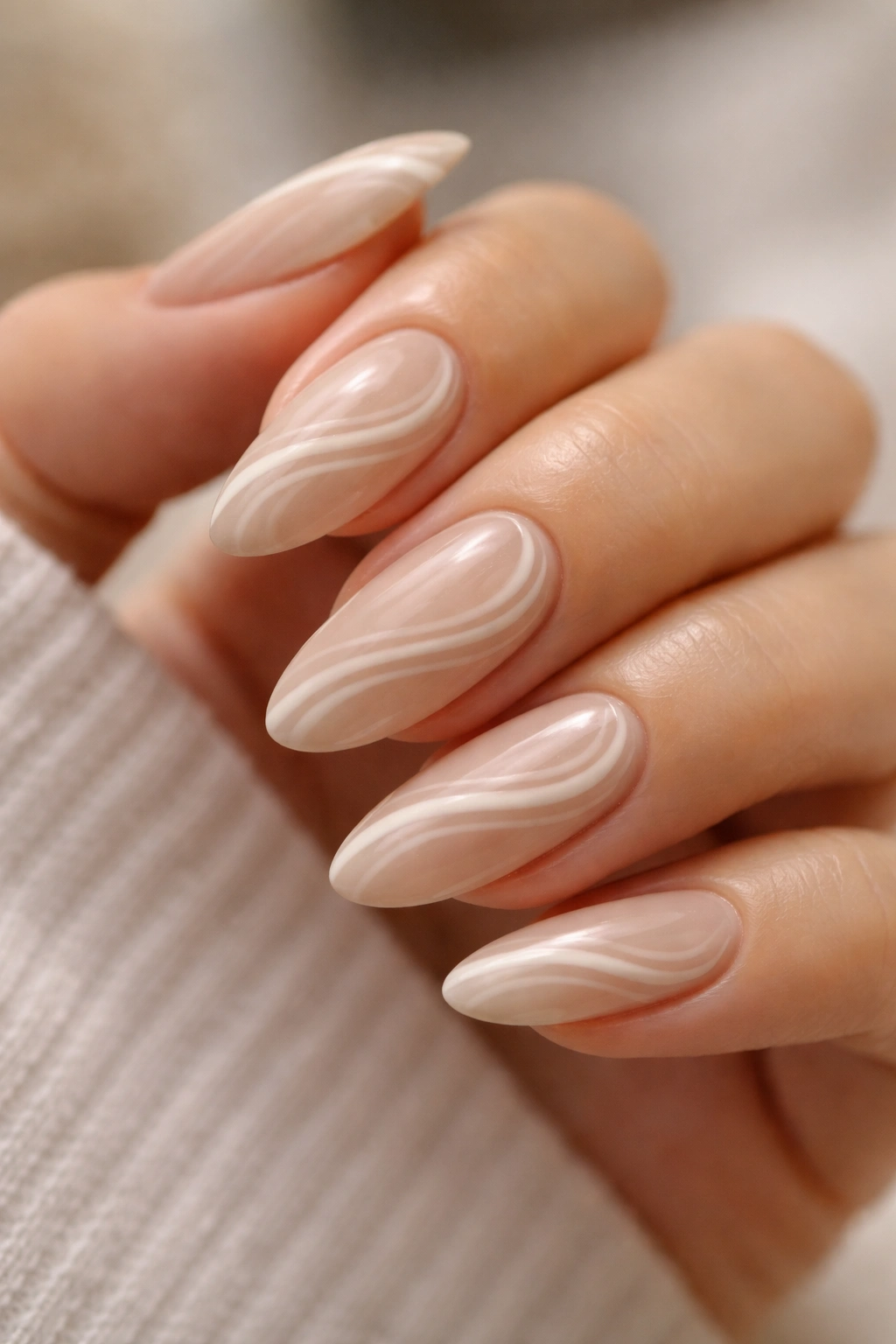 Almond nails with beige and white thin swirl accents