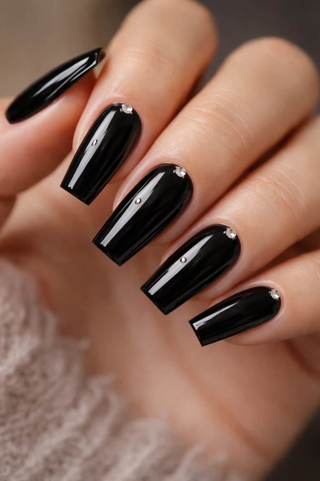 Close-up of black coffin nails with tiny crystals at the cuticle on medium coffin nails