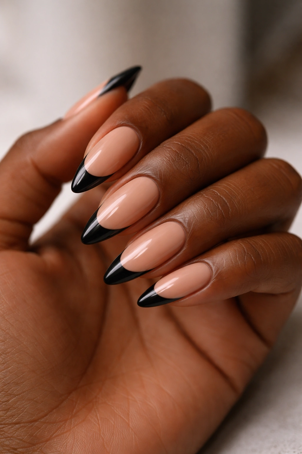 Black French nails with nude base on almond shape