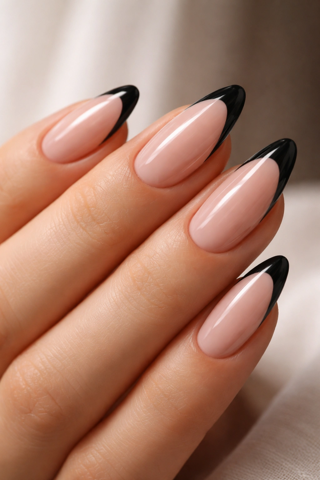 Almond nails with black French tips on a bare base.