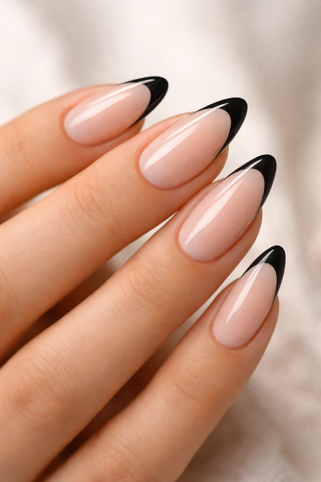 Almond nails with milky nude base and black tips