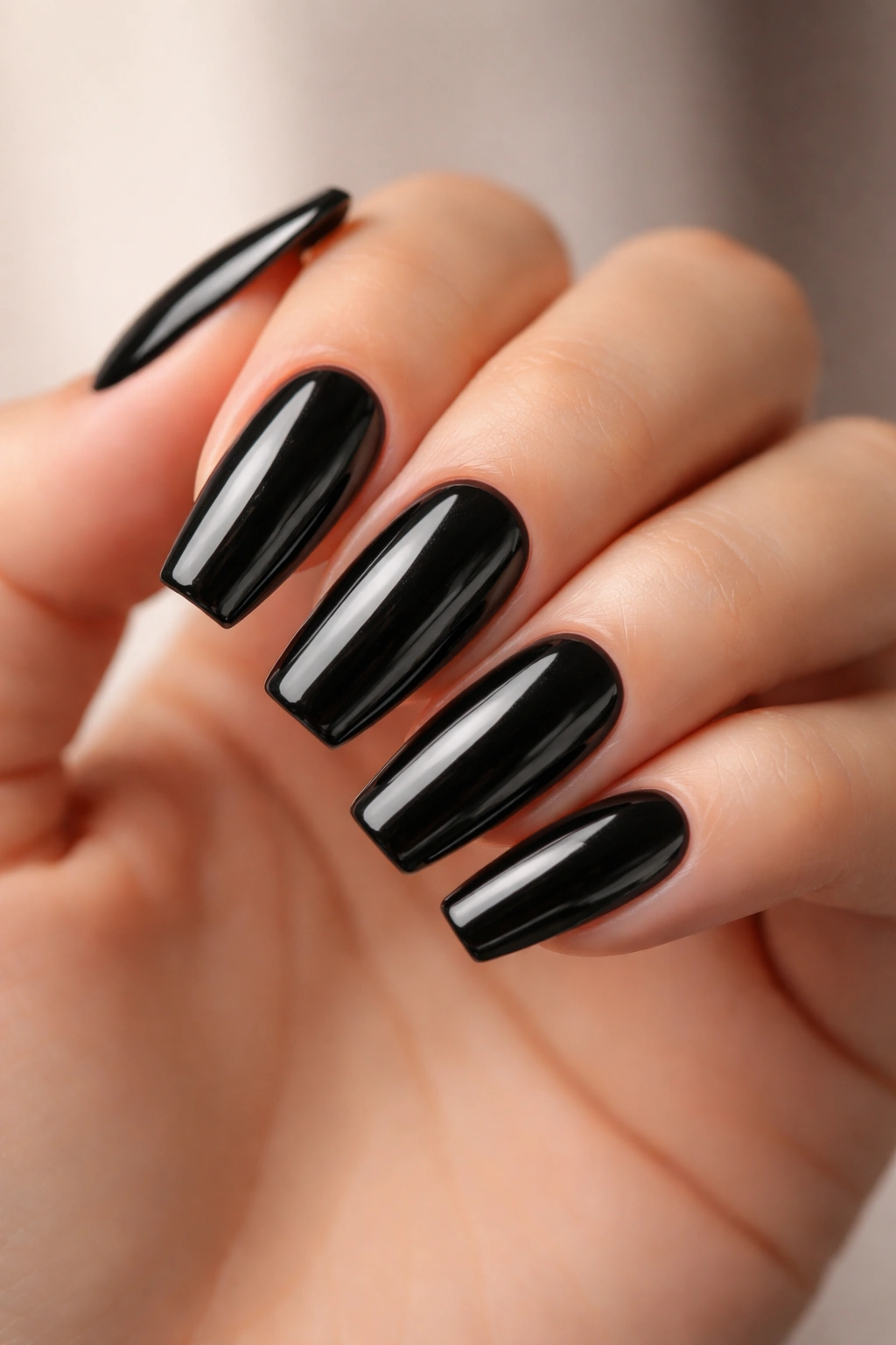 Close-up of black glass coffin nails with glassy deep reflection on a short coffin nail