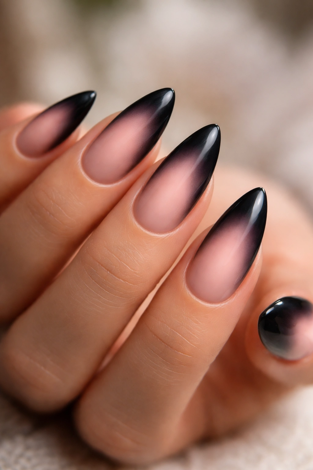 Close-up of black aura nails with a soft pink center