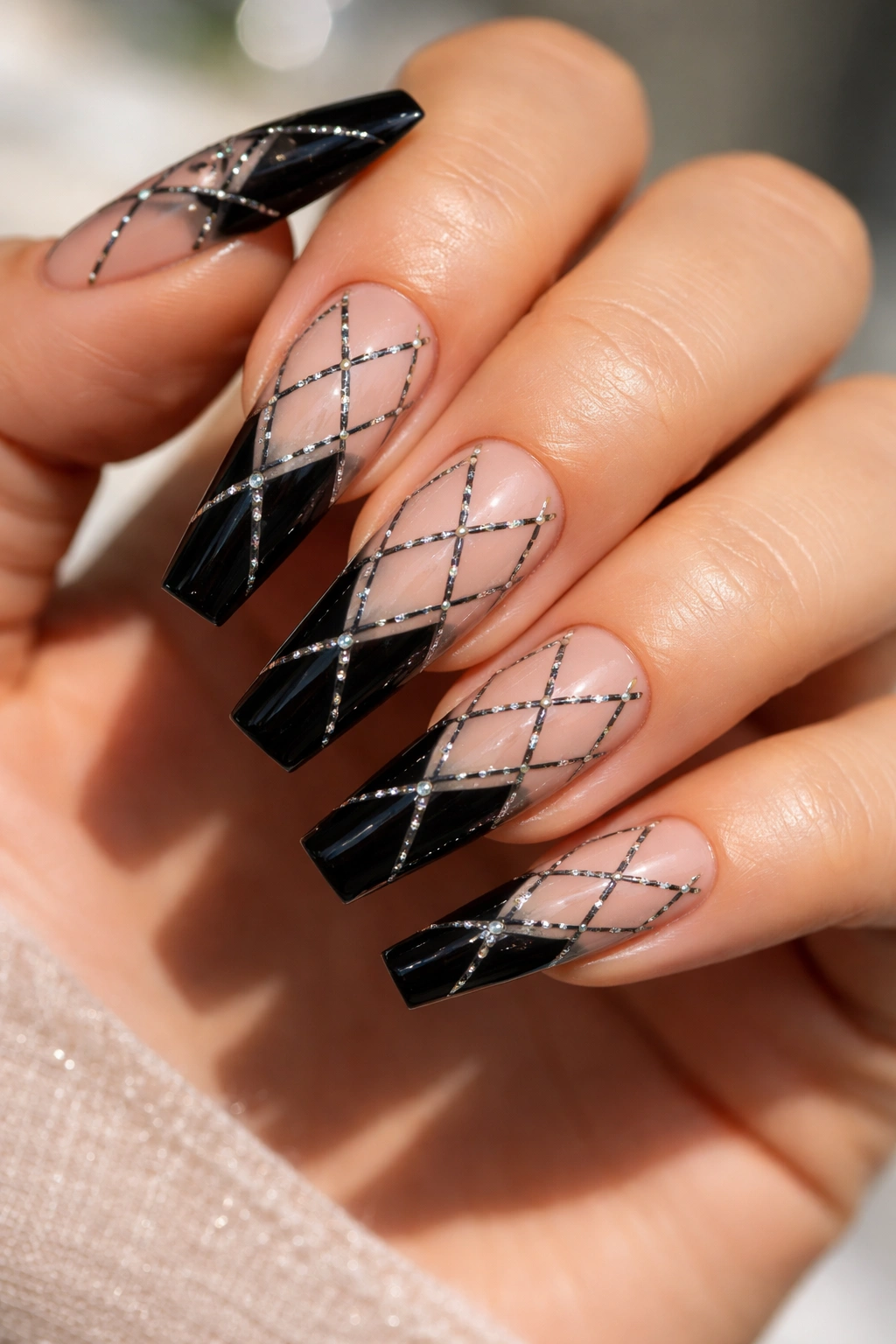 Black and nude coffin nails with crosshatch crystal grids on a neutral background