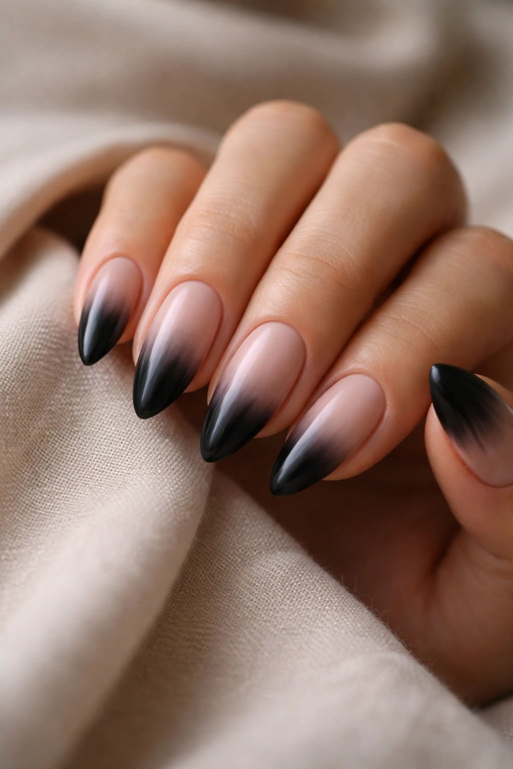 Nude-based almond nails with smooth black ombre fade