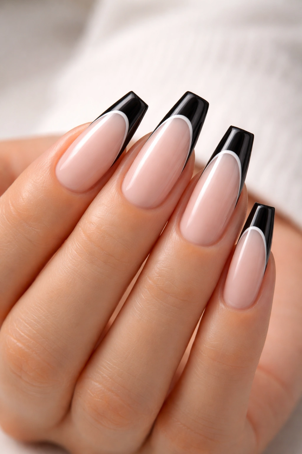 Close-up of coffin nails with black tips framed by an ultra-thin white line.
