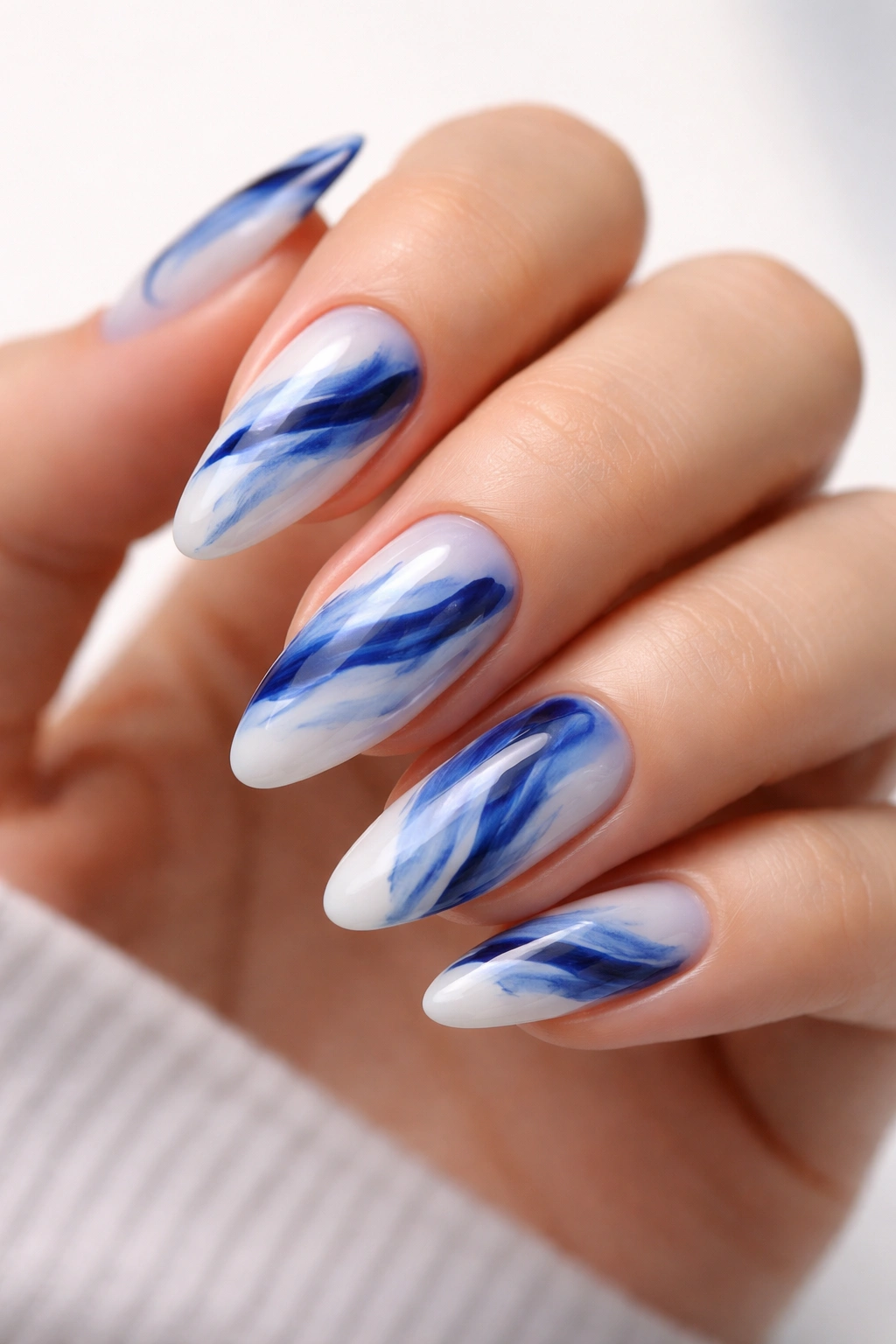 Abstract blue brushstroke nails on almond shape close-up