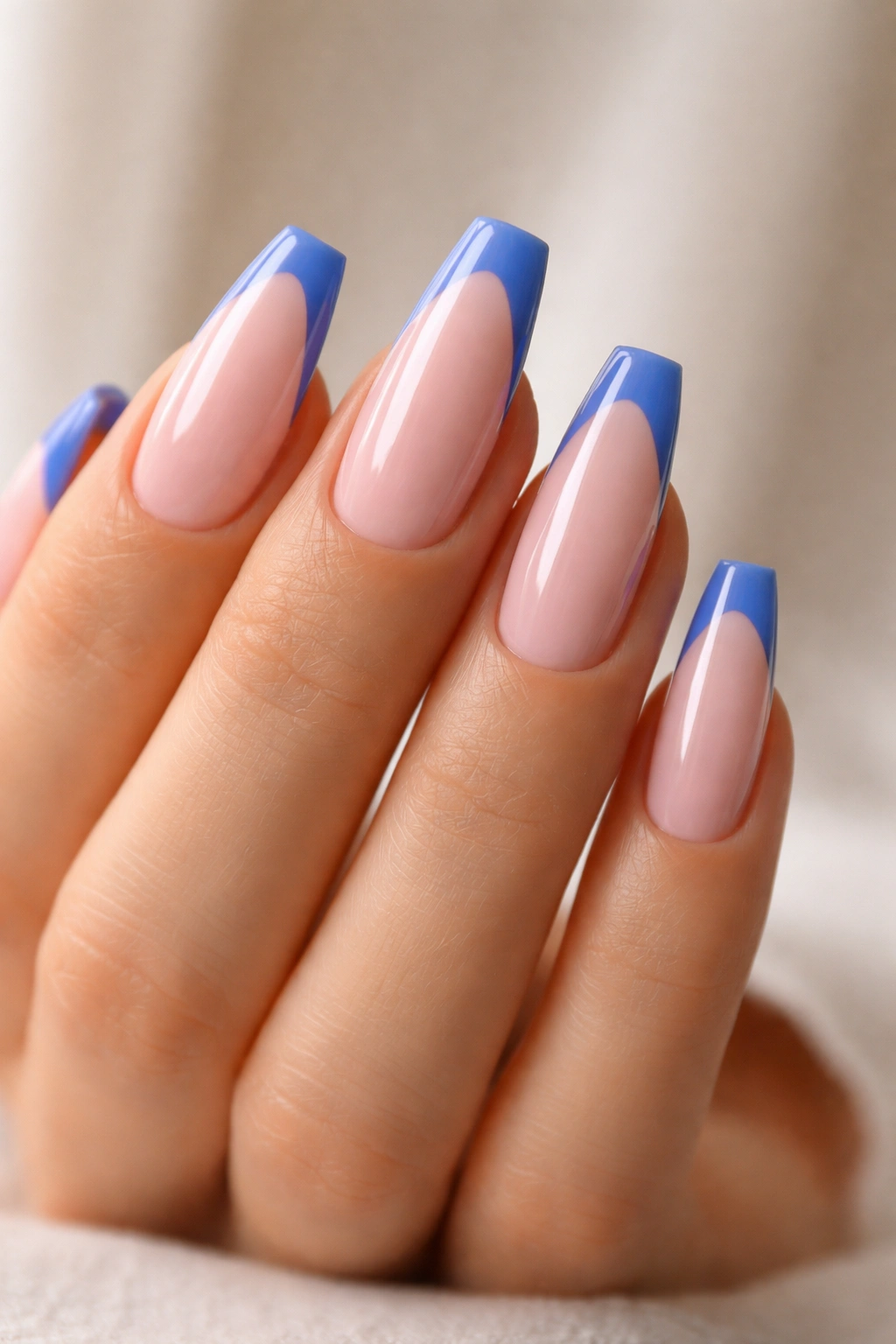 Close-up of coffin nails with sheer pink base and blue tips, crisp line